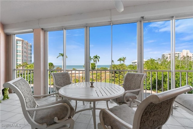 sunroom featuring a water view