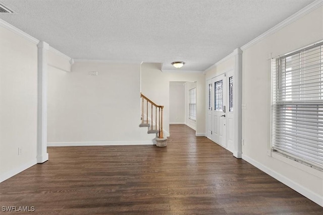 entrance foyer featuring ornamental molding, a textured ceiling, and dark hardwood / wood-style flooring