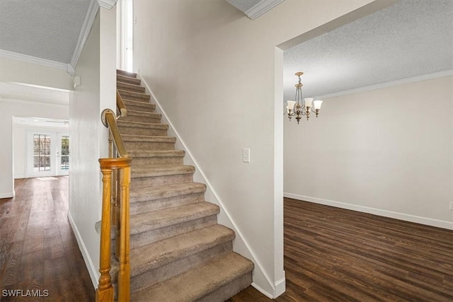 staircase with crown molding, french doors, a textured ceiling, and hardwood / wood-style flooring