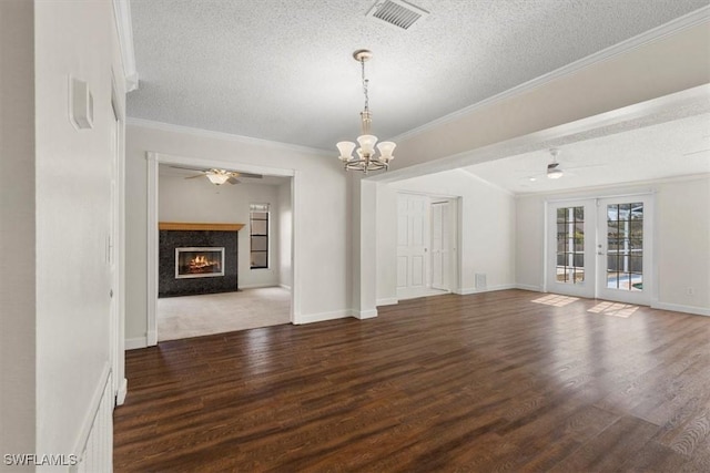 unfurnished living room with dark hardwood / wood-style flooring, ornamental molding, a fireplace, and french doors