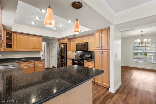 kitchen featuring pendant lighting, a raised ceiling, kitchen peninsula, stainless steel appliances, and dark wood-type flooring