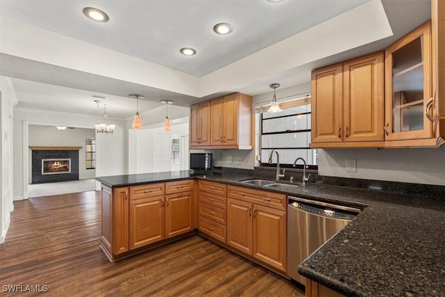 kitchen with hanging light fixtures, dishwasher, sink, and kitchen peninsula