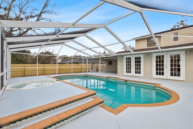 view of pool featuring french doors, an in ground hot tub, a lanai, and a patio