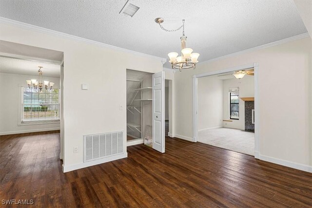 unfurnished dining area with a healthy amount of sunlight, dark hardwood / wood-style flooring, a chandelier, and a textured ceiling