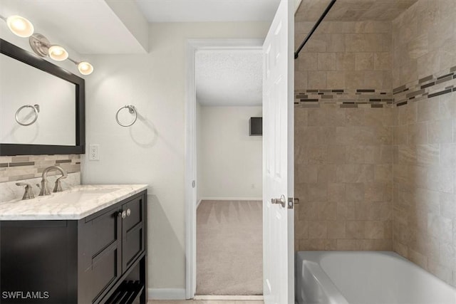 bathroom with decorative backsplash, tiled shower / bath, vanity, and a textured ceiling