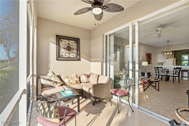 sunroom featuring ceiling fan with notable chandelier