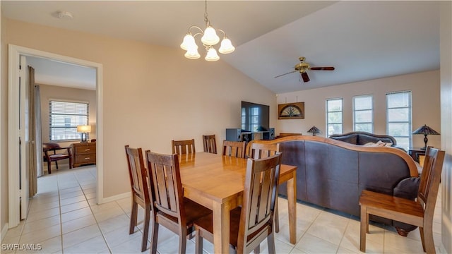 tiled dining space featuring ceiling fan with notable chandelier and vaulted ceiling