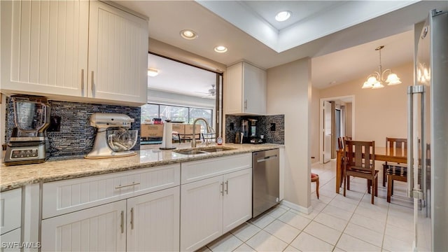 kitchen with dishwasher, light stone countertops, sink, and white cabinets