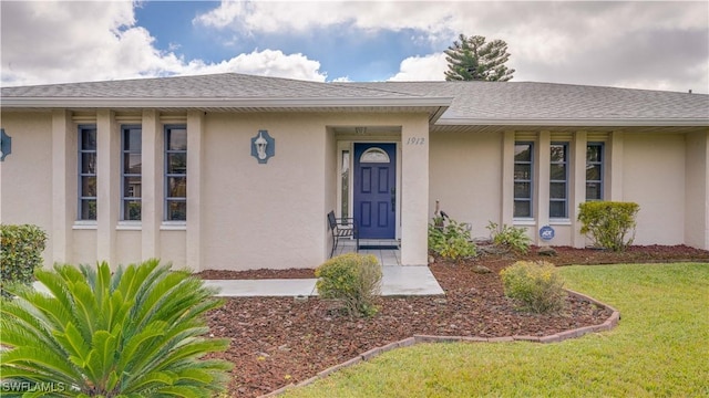 property entrance with a lawn