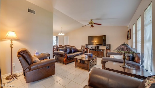 tiled living room with ceiling fan with notable chandelier, vaulted ceiling, and a wealth of natural light