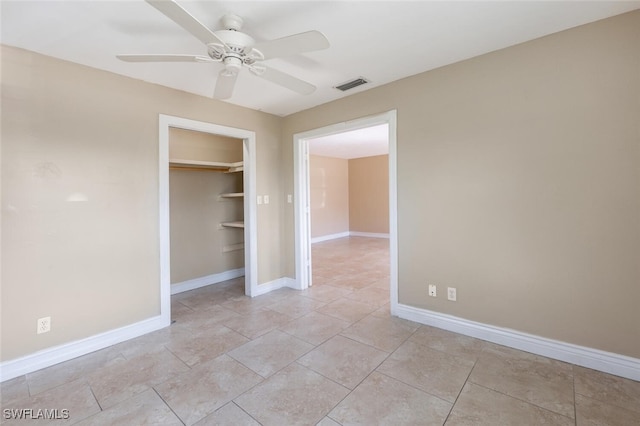 interior space featuring light tile patterned flooring, ceiling fan, and a closet