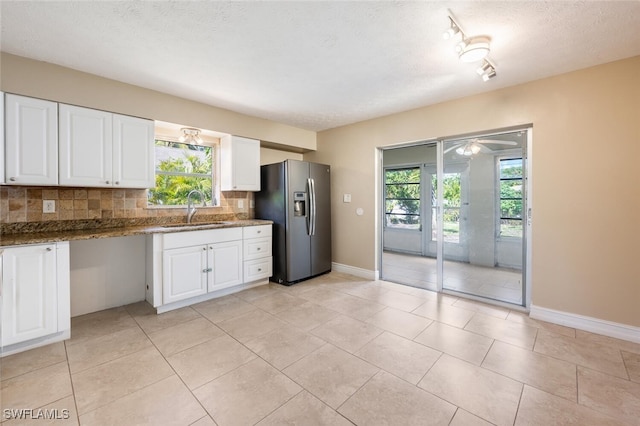 kitchen featuring sink, backsplash, white cabinets, and stainless steel refrigerator with ice dispenser