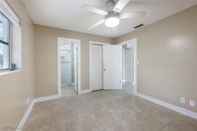 unfurnished bedroom featuring ceiling fan, ensuite bathroom, and a closet