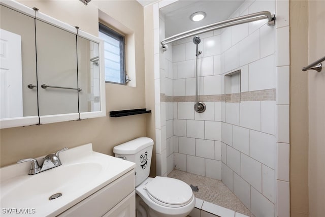 bathroom featuring vanity, toilet, and a tile shower