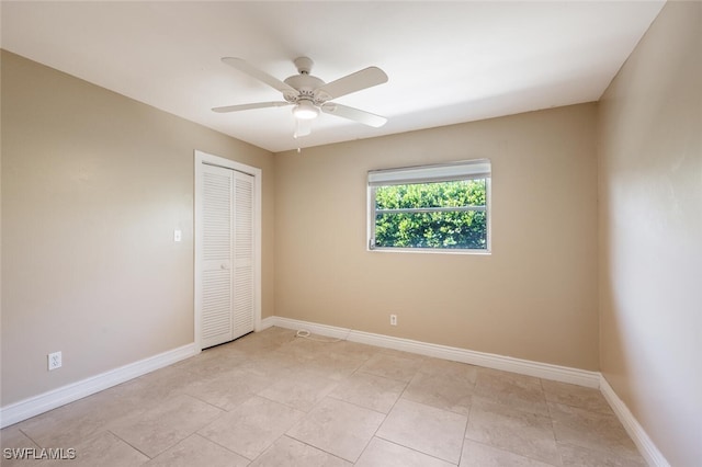 unfurnished bedroom with light tile patterned floors, ceiling fan, and a closet