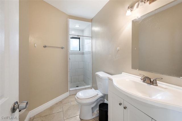 bathroom featuring tile patterned flooring, vanity, a tile shower, and toilet