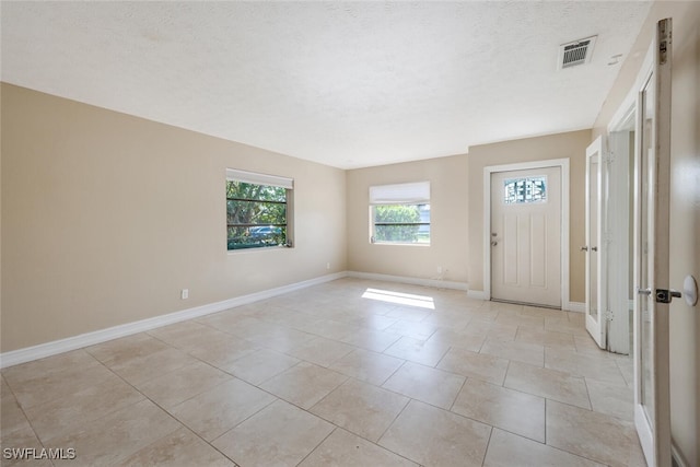 tiled foyer entrance with a textured ceiling