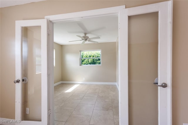 empty room with ceiling fan and light tile patterned floors