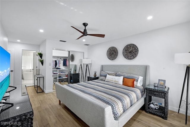 bedroom featuring ceiling fan, connected bathroom, a closet, and light wood-type flooring