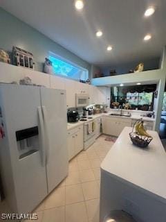 kitchen with sink, light tile patterned floors, white cabinets, and white appliances