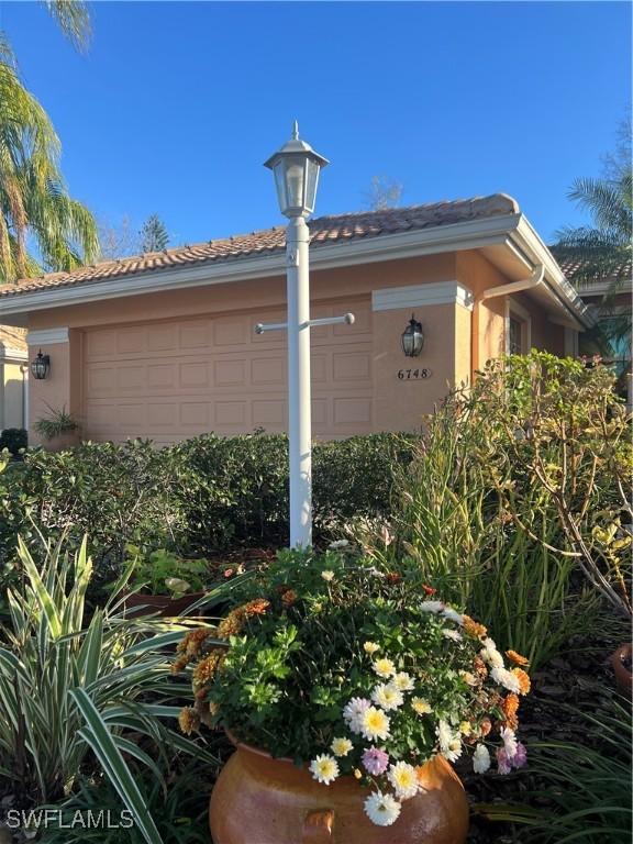 exterior space with stucco siding, a downspout, and gutters