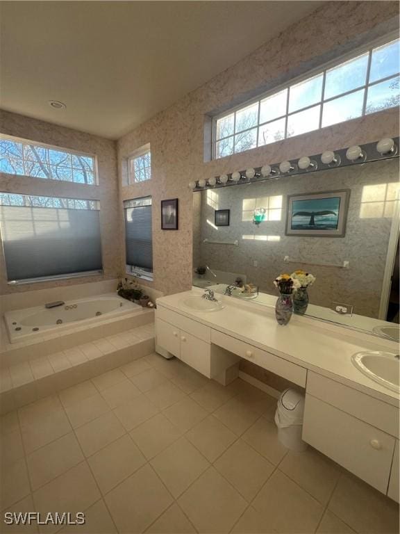 full bath with a wealth of natural light, a jetted tub, and vanity