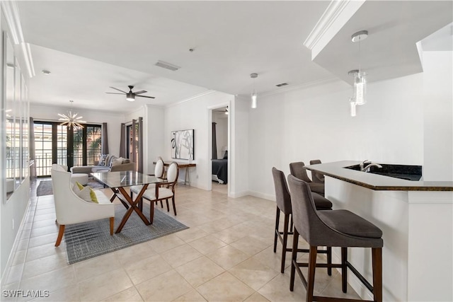 tiled dining area featuring ornamental molding and ceiling fan with notable chandelier