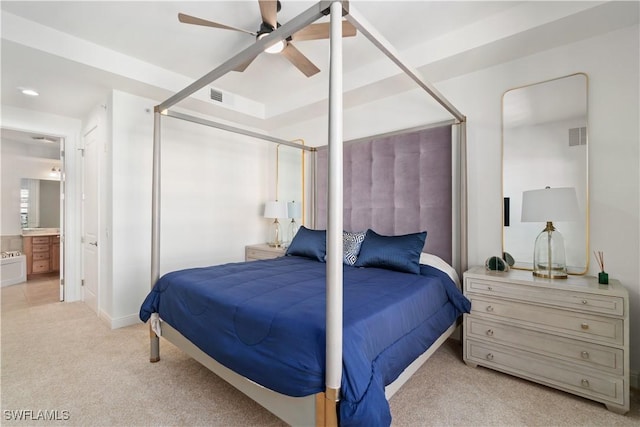 bedroom featuring ensuite bathroom, light colored carpet, and ceiling fan