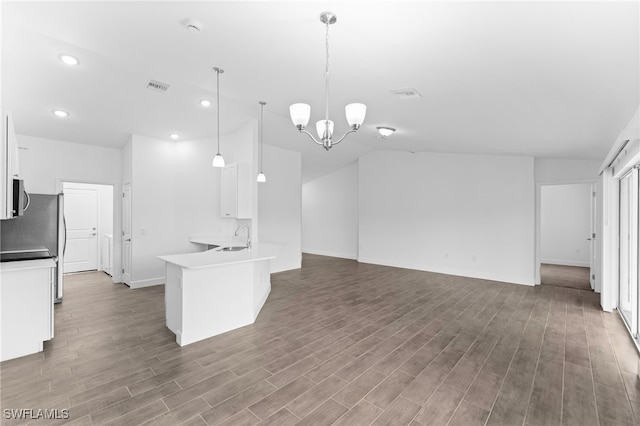 kitchen featuring white cabinetry, an inviting chandelier, decorative light fixtures, kitchen peninsula, and hardwood / wood-style floors