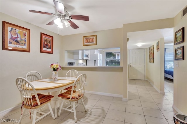 tiled dining room featuring ceiling fan