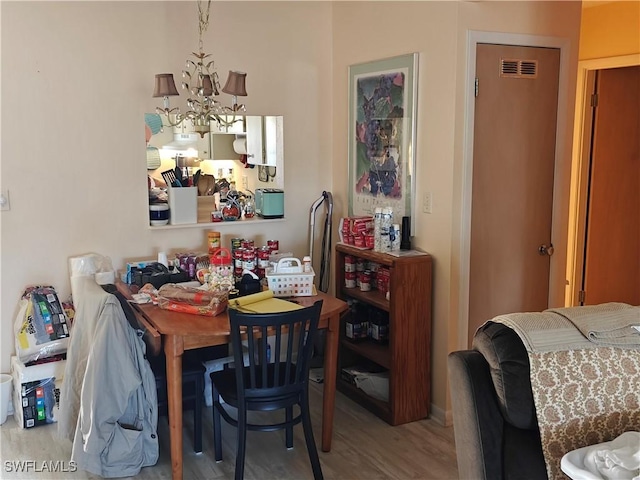 dining space with hardwood / wood-style flooring and a notable chandelier