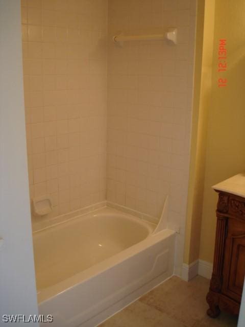 bathroom with tiled shower / bath, tile patterned floors, and vanity