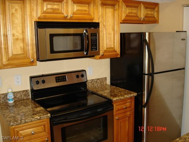 kitchen with light stone counters and appliances with stainless steel finishes