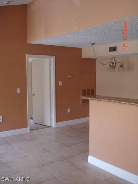 tiled spare room with a textured ceiling