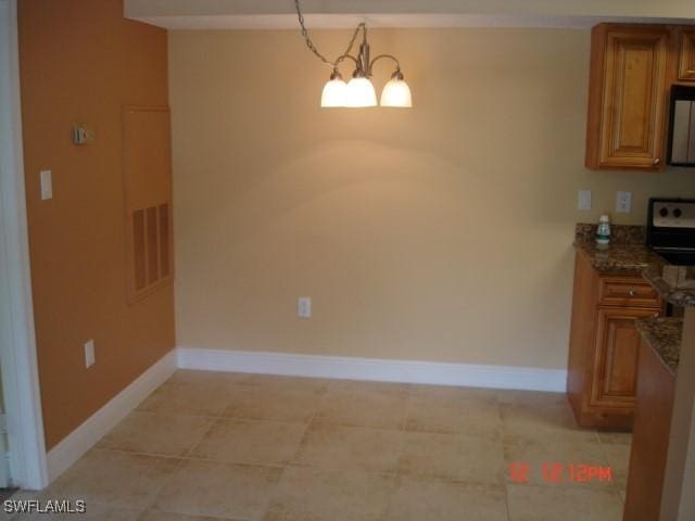 dining area with light tile patterned floors and an inviting chandelier