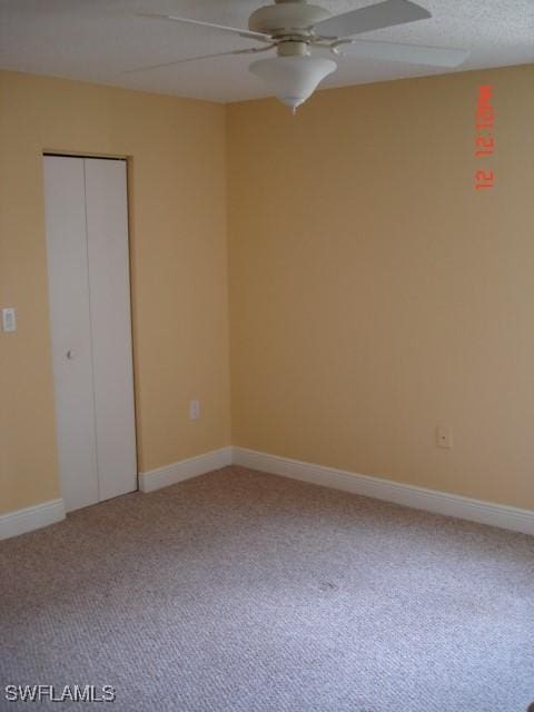 unfurnished bedroom featuring ceiling fan, a closet, carpet floors, and a textured ceiling