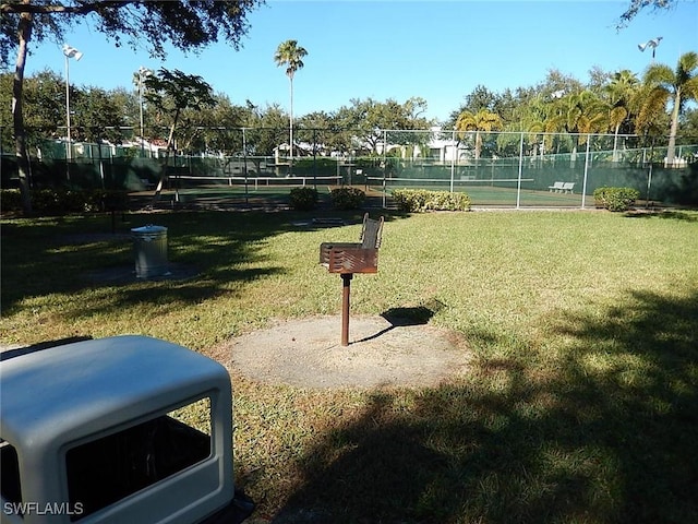 surrounding community with a lawn and volleyball court