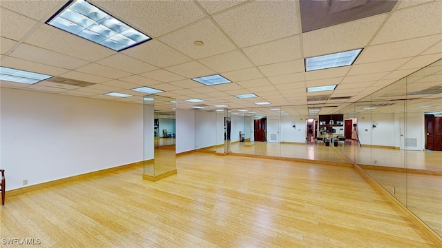 empty room with hardwood / wood-style flooring and a paneled ceiling