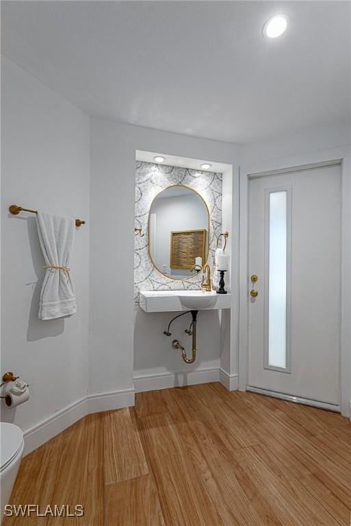 bathroom with hardwood / wood-style flooring and toilet