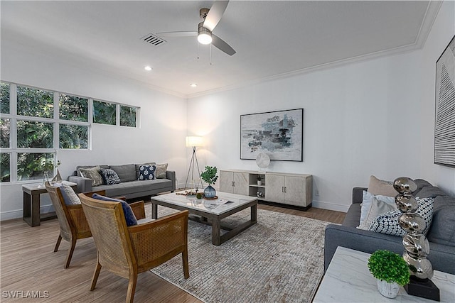 living room featuring ceiling fan, ornamental molding, hardwood / wood-style floors, and plenty of natural light