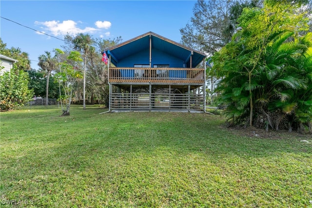 rear view of property with a wooden deck and a lawn