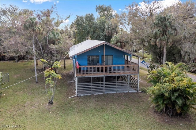 rear view of house featuring a yard and a deck