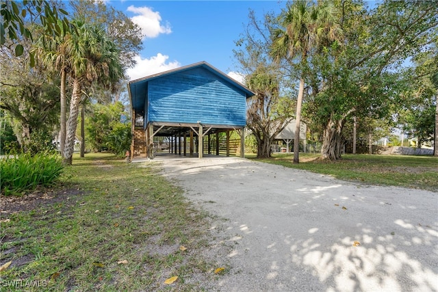 view of home's exterior with a lawn and a carport