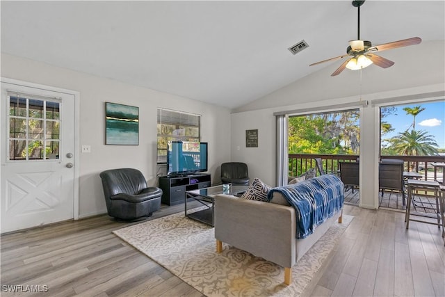 living room featuring lofted ceiling, plenty of natural light, and light hardwood / wood-style floors