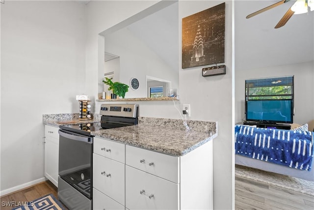 kitchen featuring electric stove, ceiling fan, white cabinetry, light stone countertops, and light hardwood / wood-style floors