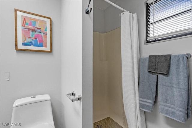 bathroom featuring toilet and a shower with shower curtain