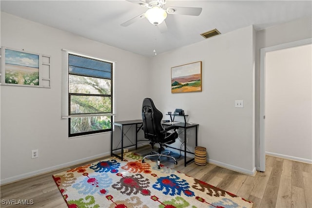 home office with ceiling fan and light hardwood / wood-style flooring