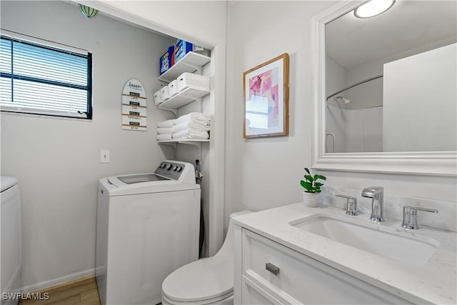 bathroom with toilet, a shower, wood-type flooring, washer and dryer, and vanity