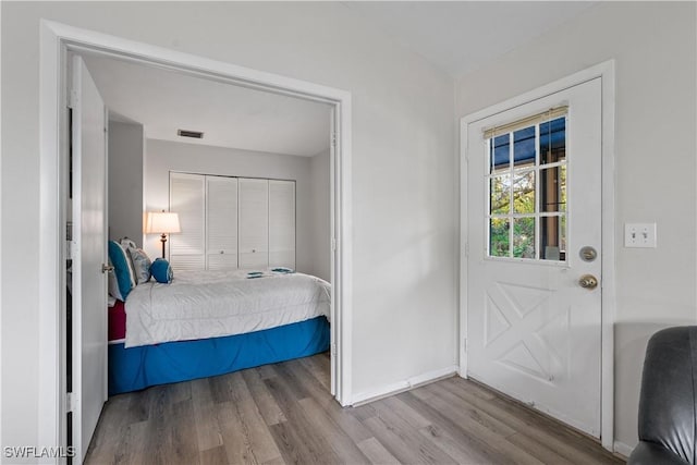 bedroom with light hardwood / wood-style floors and a closet