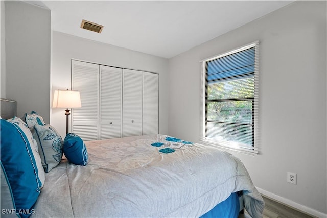 bedroom with hardwood / wood-style floors and a closet